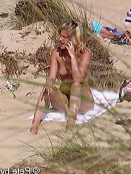 A mature woman feels that she is not being watched on a beach for nudists.